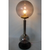 Stylowa lampa retro z kulistym szklanym kloszem i niklowanym trzonem, idealna do nowoczesnych wnętrz.