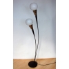 Lampa podłogowa Mid-Century ustawiona obok fotela w stylu retro – ciepłe, nastrojowe oświetlenie.