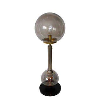 Modernistyczna lampa stołowa z lat 70. wykonana ze szkła i stali niklowanej, ustawiona na czarnym stoliku w eleganckim w
