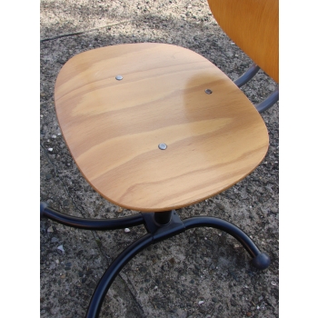 Zestaw 4 vintage krzeseł marki Kinnarps z lat 70., ustawionych w okręgu. Wyróżnia się metalową podstawą i ergonomicznym drewnianym siedziskiem.