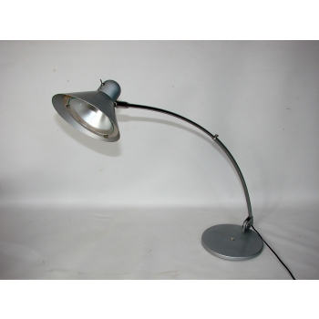 Lampa biurkowa z lat 80. włączona – stożkowy klosz rzuca skupione światło na blat.